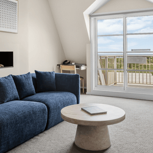 Lounge room featuring lounge suite , occasional chairs, and coffee table with window and balcony in background